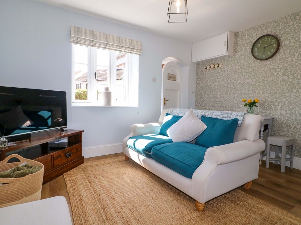 A living room with a sofa and television at Prospect Cottage in 