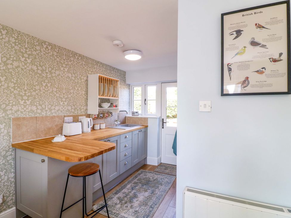 A kitchen with appliances and a door at Prospect Cottage