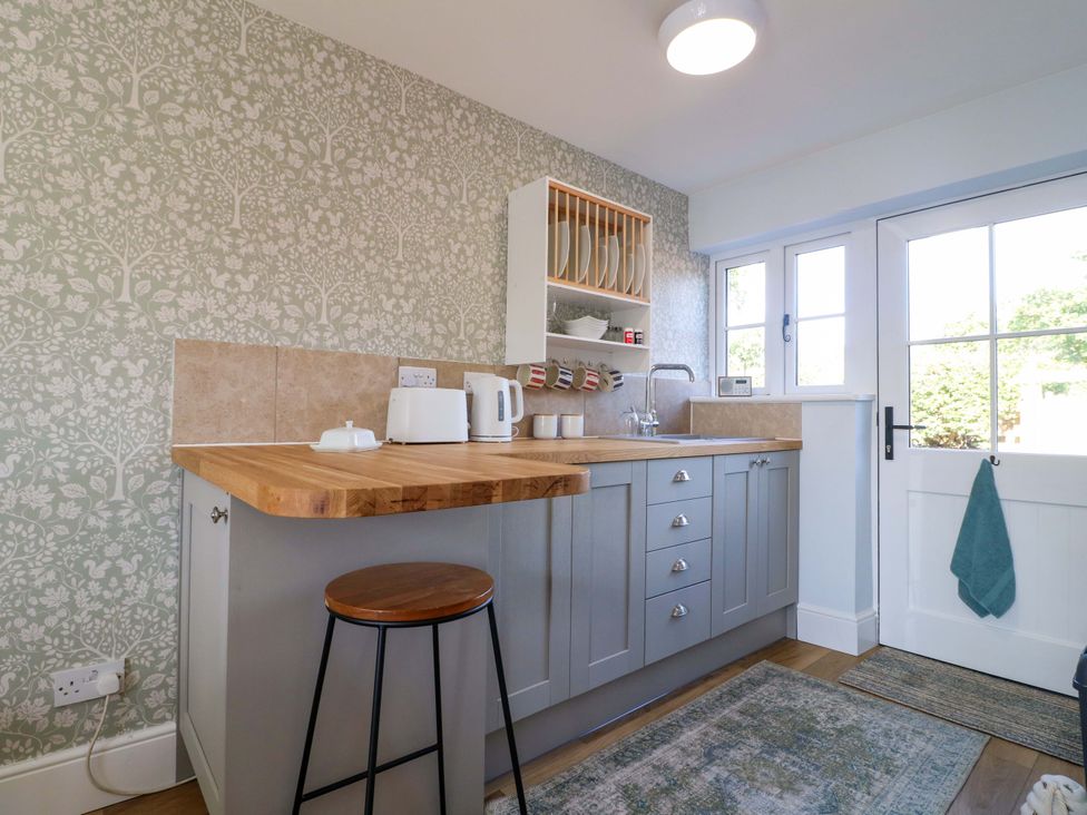 A kitchen with countertop and bar stool at Prospect Cottage