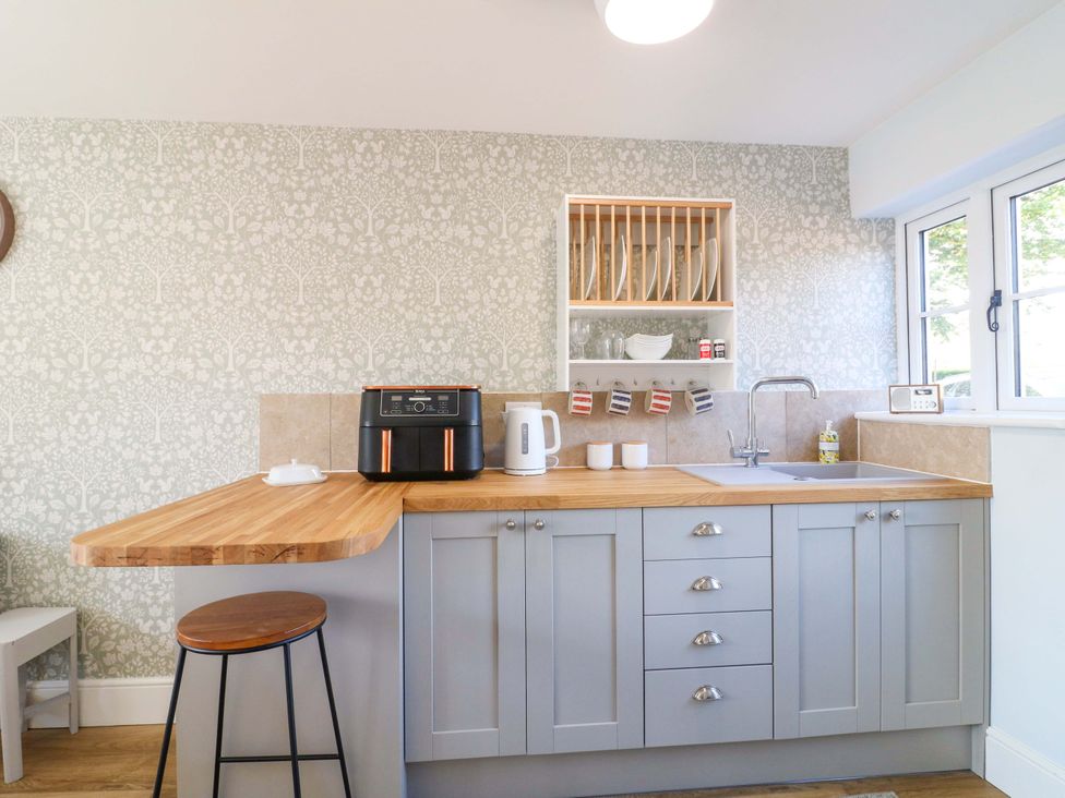 A kitchen with a countertop, sink, kettle and air fryer at Prospect Cottage
