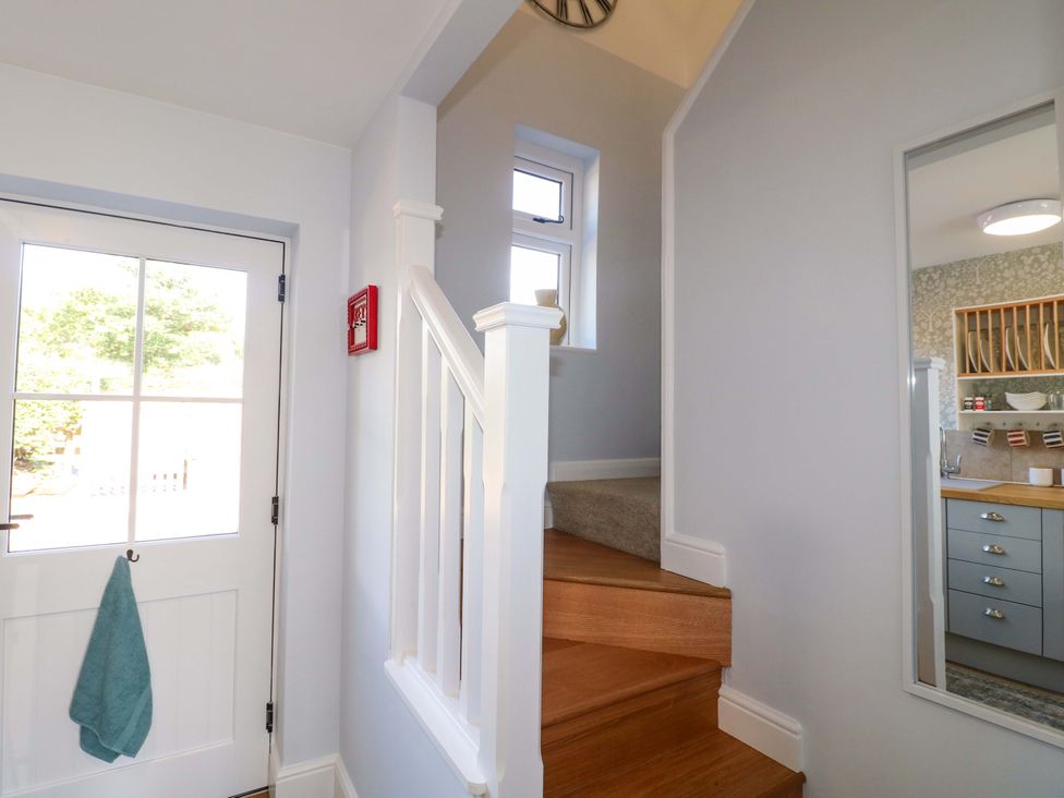 A hallway with a staircase and door at Prospect Cottage