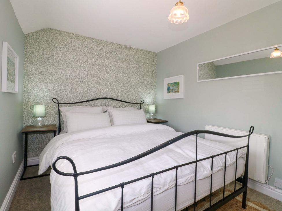 A bedroom with a bed and nightstand at Prospect Cottage