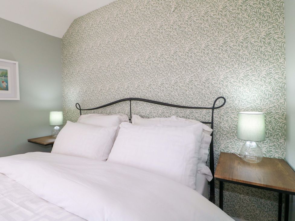 A bedroom with a bed and bedside tables at Prospect Cottage