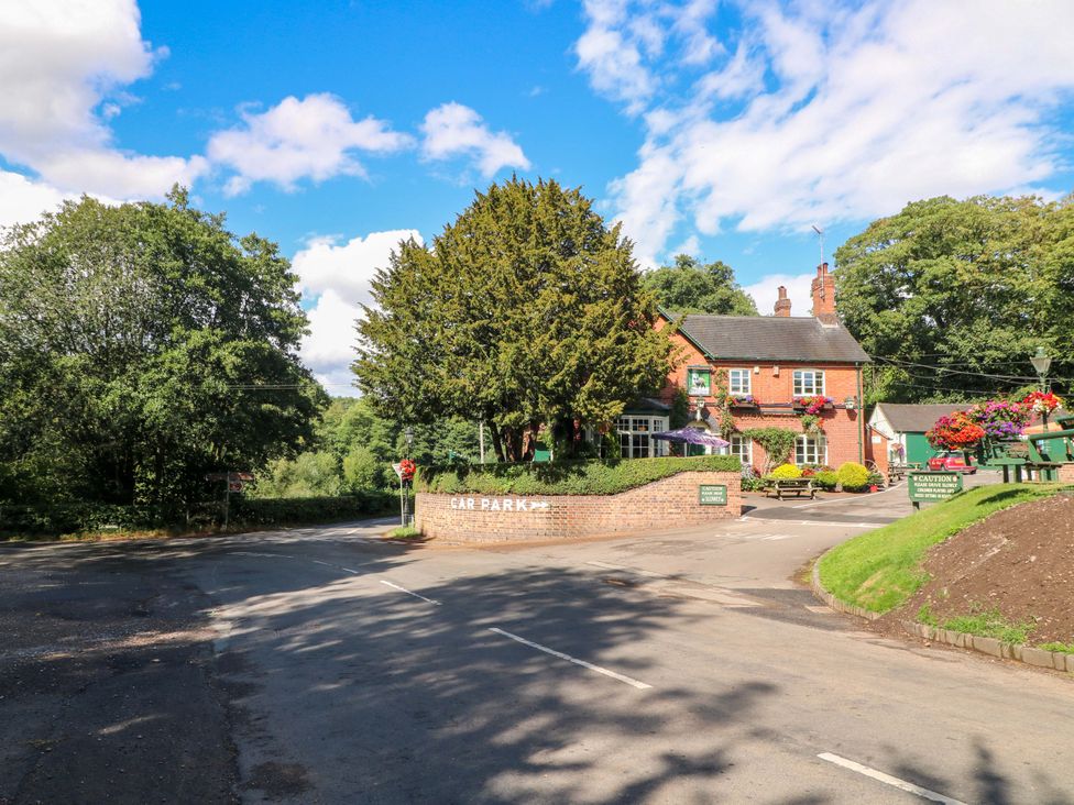 A car park and a building with trees and flowers outside at Prospect Cottage
