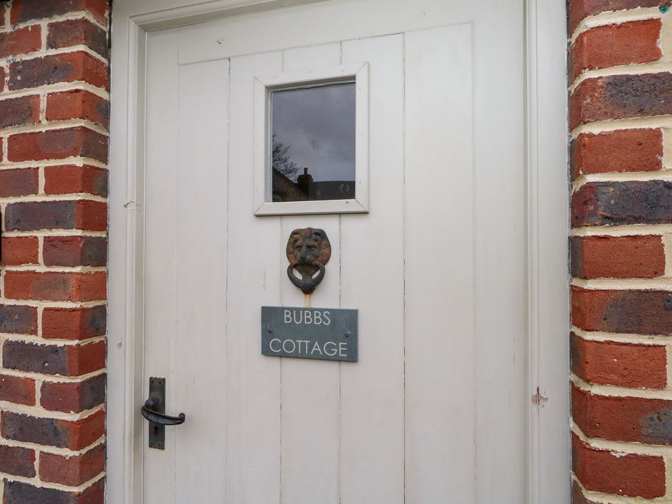 A door with a lion knocker and a name plate at Bubbs Cottage