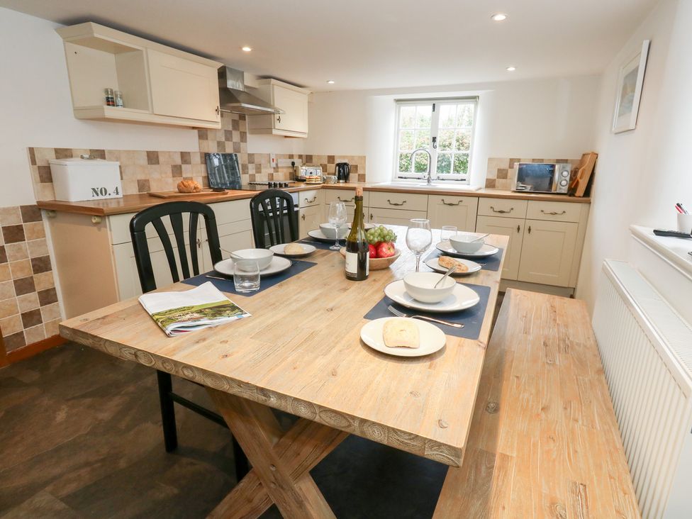 A kitchen with a wooden table and chairs at Bubbs Cottage 