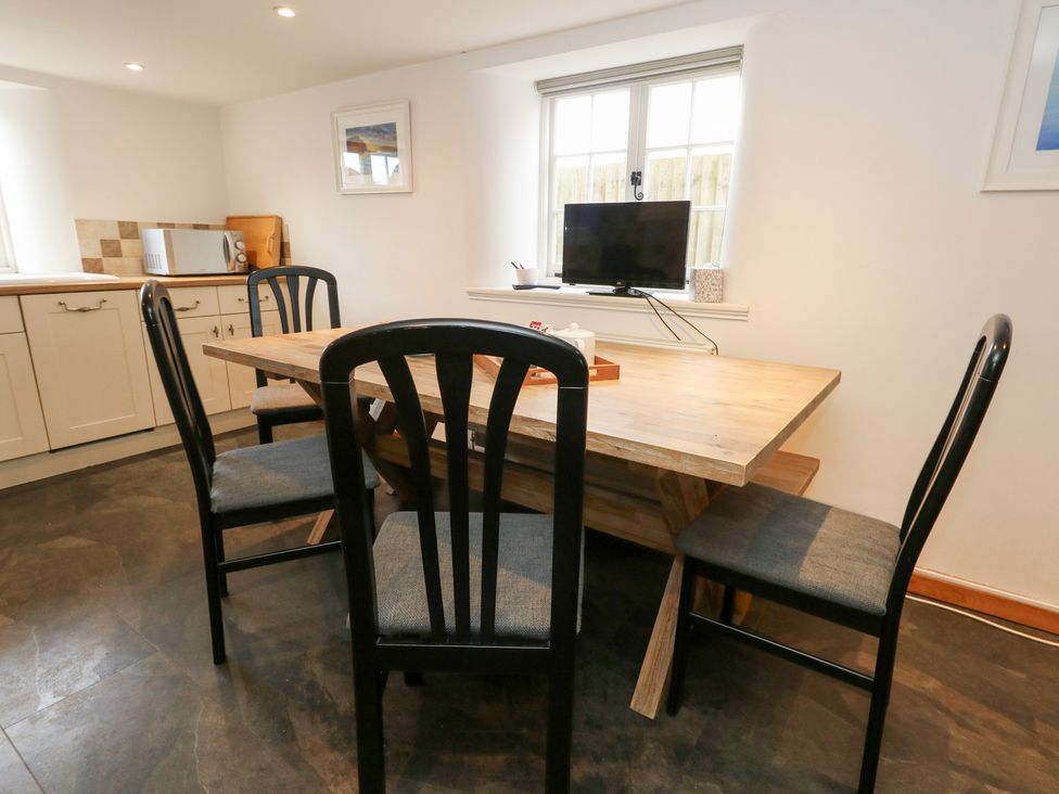 A kitchen with a dining table and chairs at Bubbs Cottage