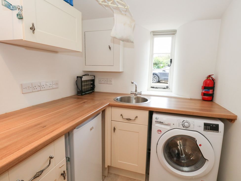 A laundry room with a sink and washing machine at Bubbs Cottage