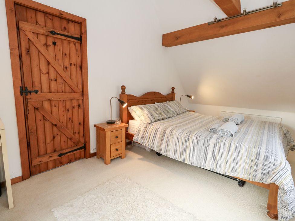 A bedroom with a bed and wooden door at Bubbs Cottage 