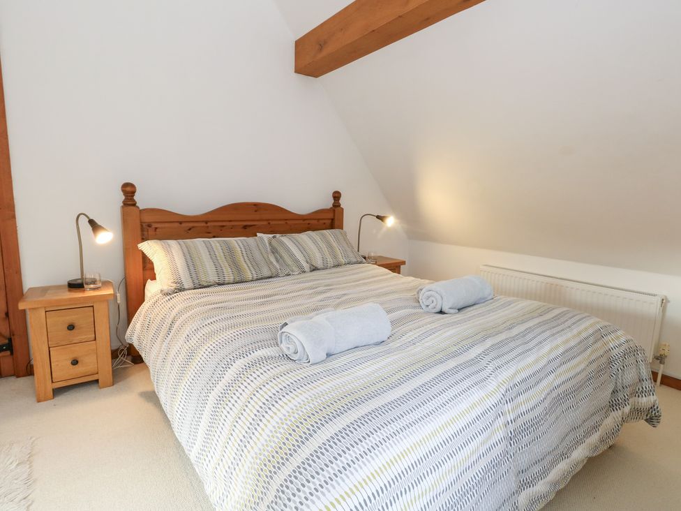 A bedroom with a bed and nightstand at Bubbs Cottage