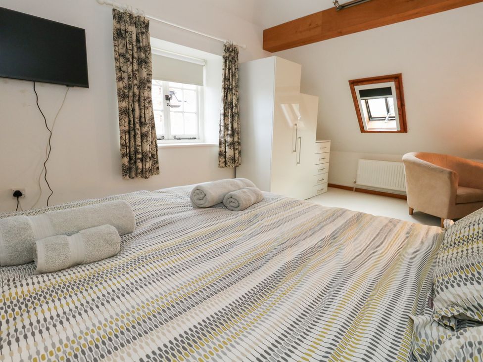 A bedroom with a bed and television at Bubbs Cottage