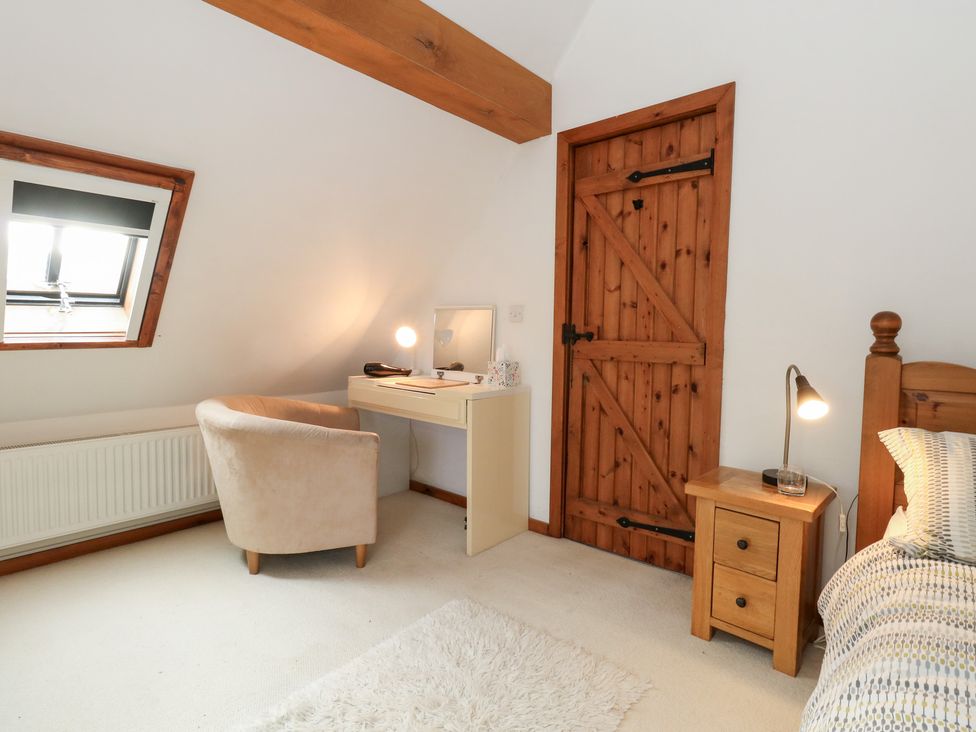 A bedroom with a desk and chair at Bubbs Cottage