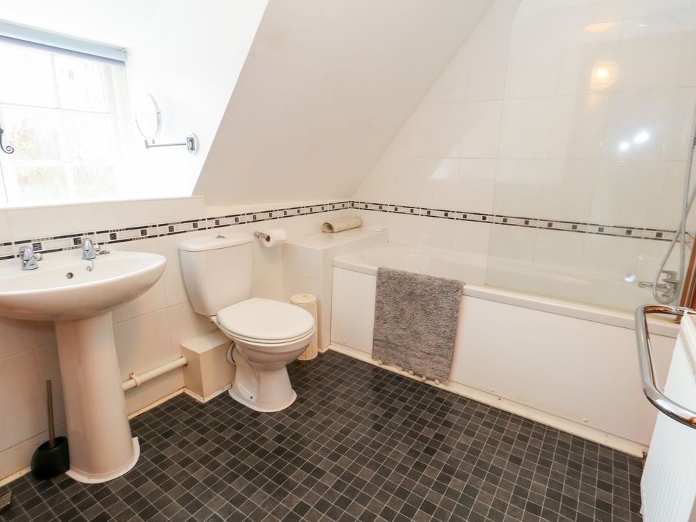 A bathroom with a sink, toilet, and bathtub at Bubbs Cottage