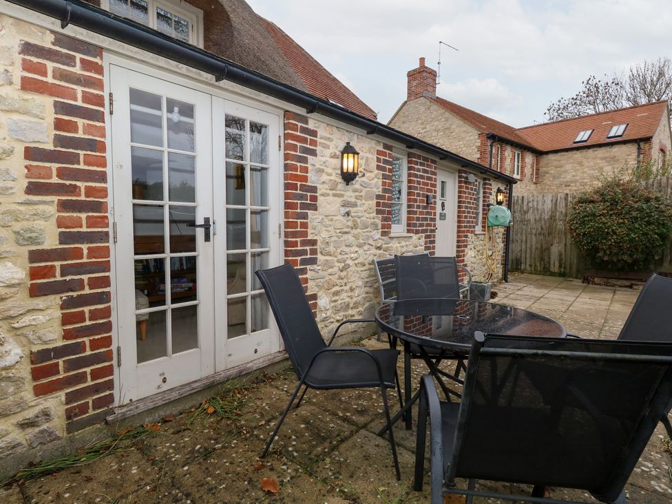An outdoor seating area with a table and chairs at Bubbs Cottage