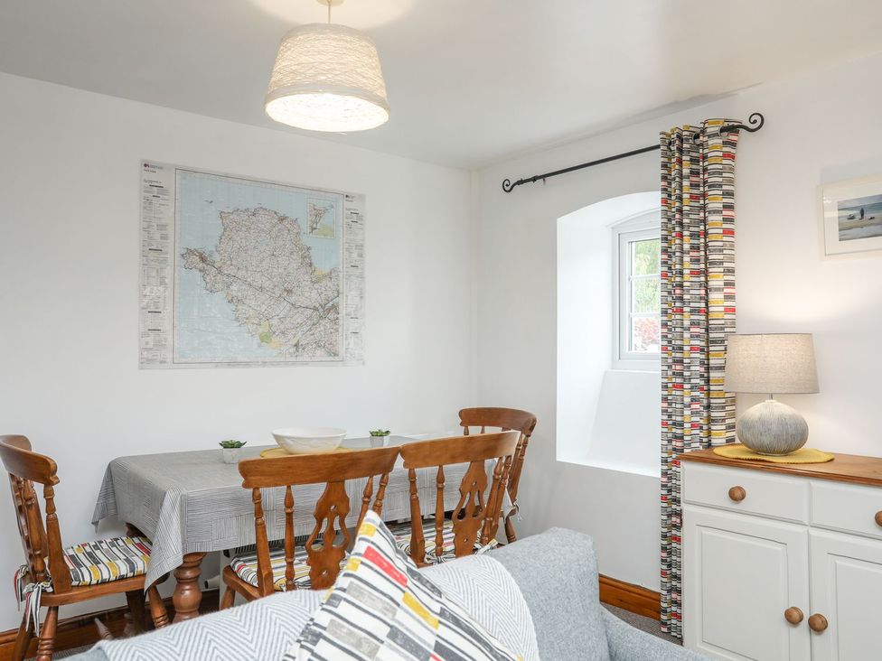 A dining room with a table and chairs at Bryn Bach in Pentraeth