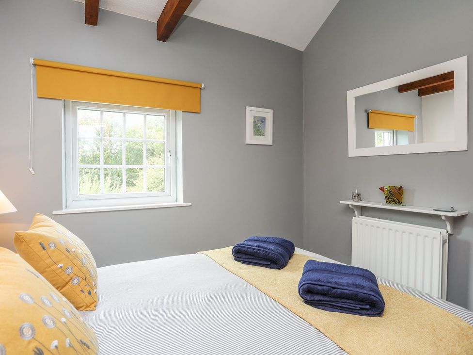 A bedroom with a bed and pillows at Bryn Bach in Pentraeth