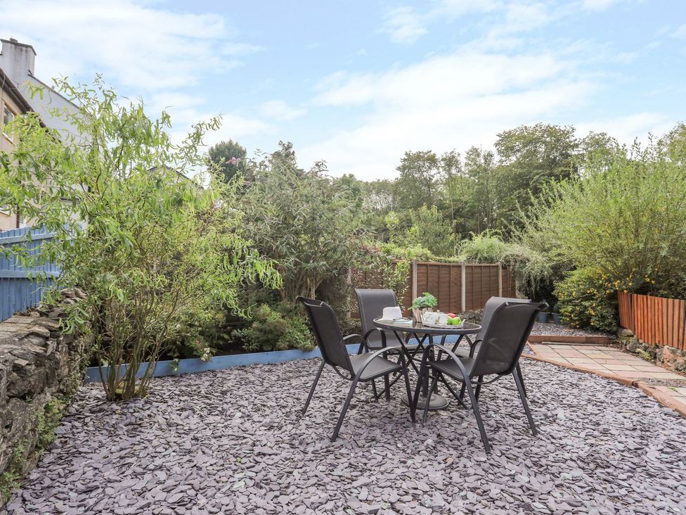 A garden with a table and chairs at Bryn Bach in Pentraeth