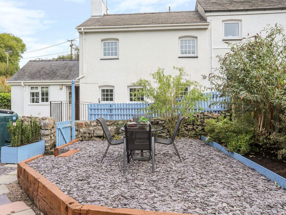 A garden with a table and chairs at Bryn Bach in Pentraeth