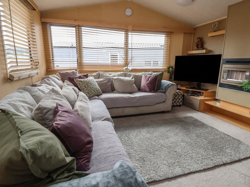 A living room with a sofa and television at Caravan 596 Prestatyn