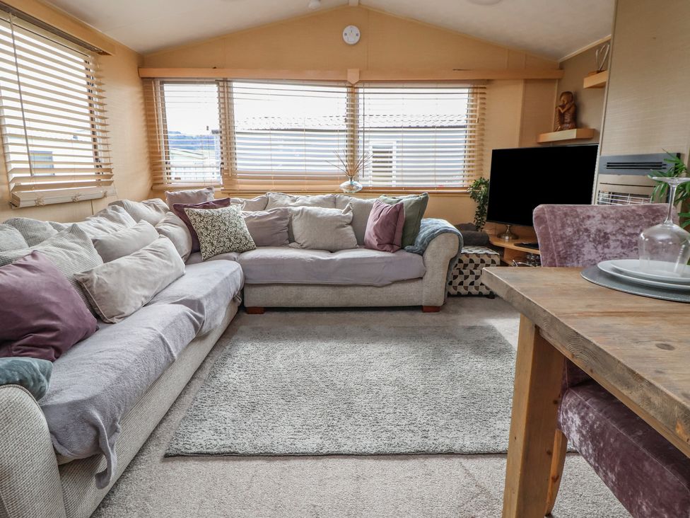 A living room with a sofa and television at Caravan 596 in Prestatyn