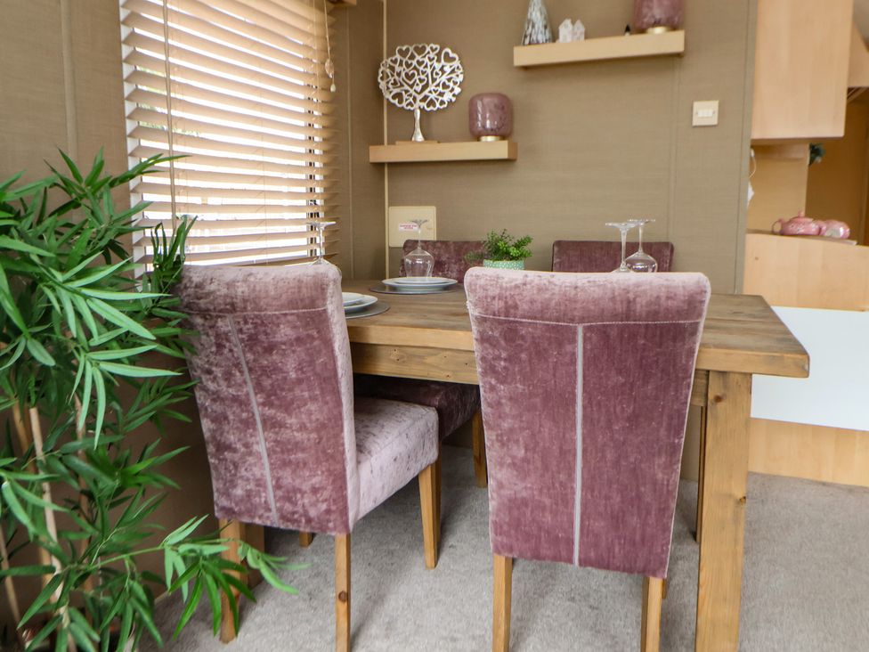 A dining area with a table and chairs at Caravan 596 Prestatyn