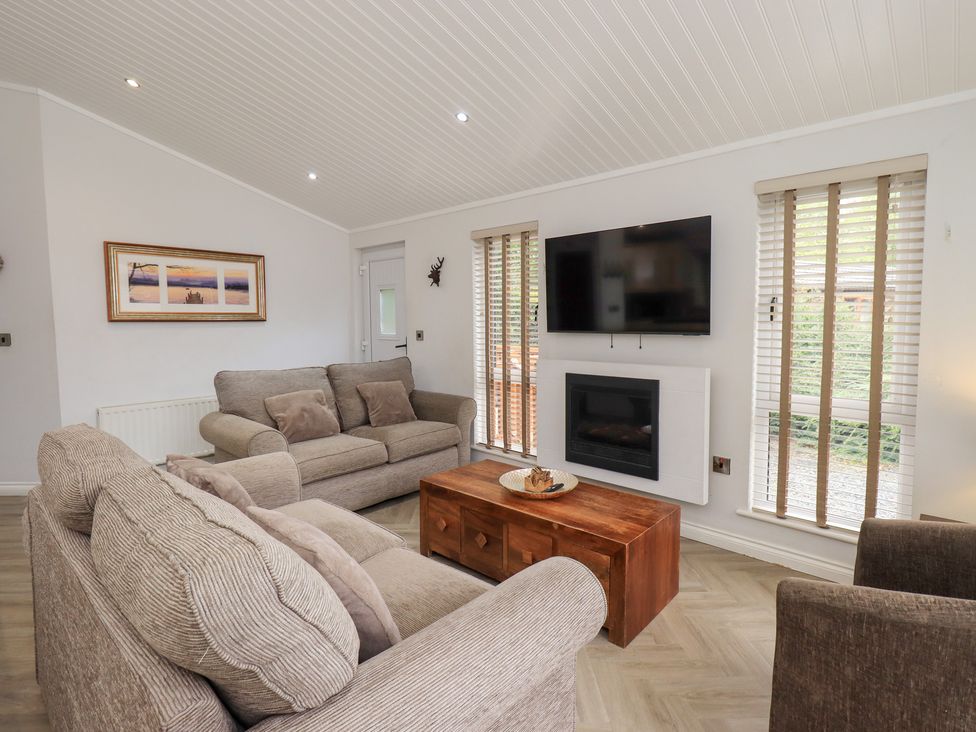 A living room with a sofa and coffee table at Laughing Duck in Troutbeck Bridge
