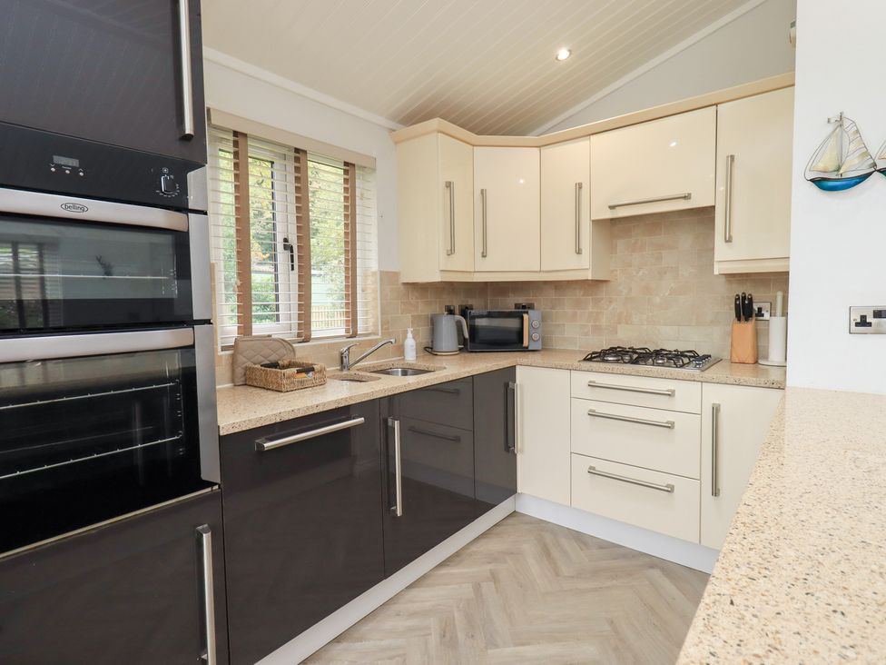 A kitchen with appliances and cabinets at Laughing Duck in Troutbeck Bridge