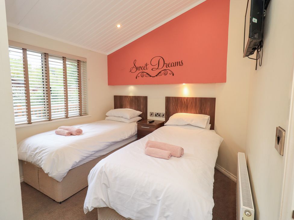 A bedroom with twin beds and a television at Laughing Duck, Troutbeck Bridge