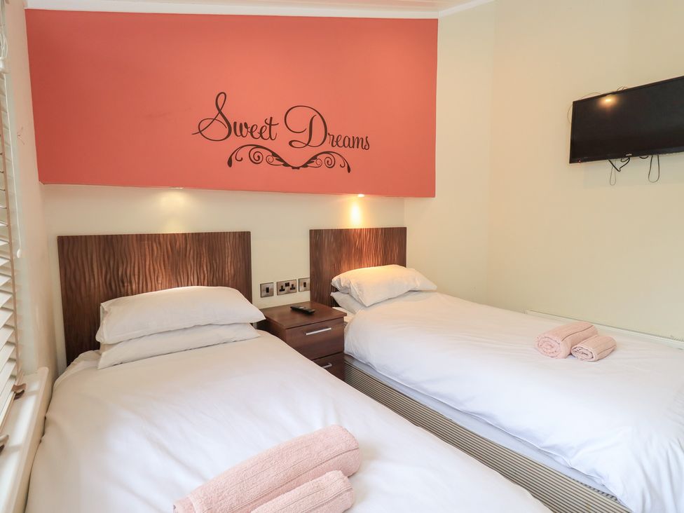 A bedroom with two beds and a television at Laughing Duck in Troutbeck Bridge