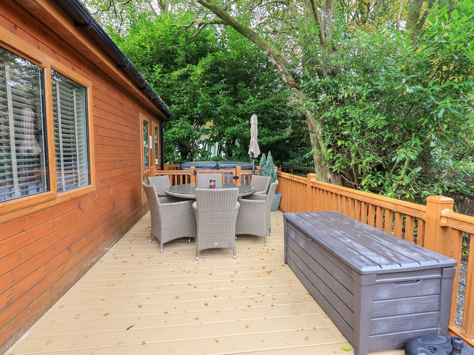 A deck area with a table and chairs at Laughing Duck in Troutbeck Bridge