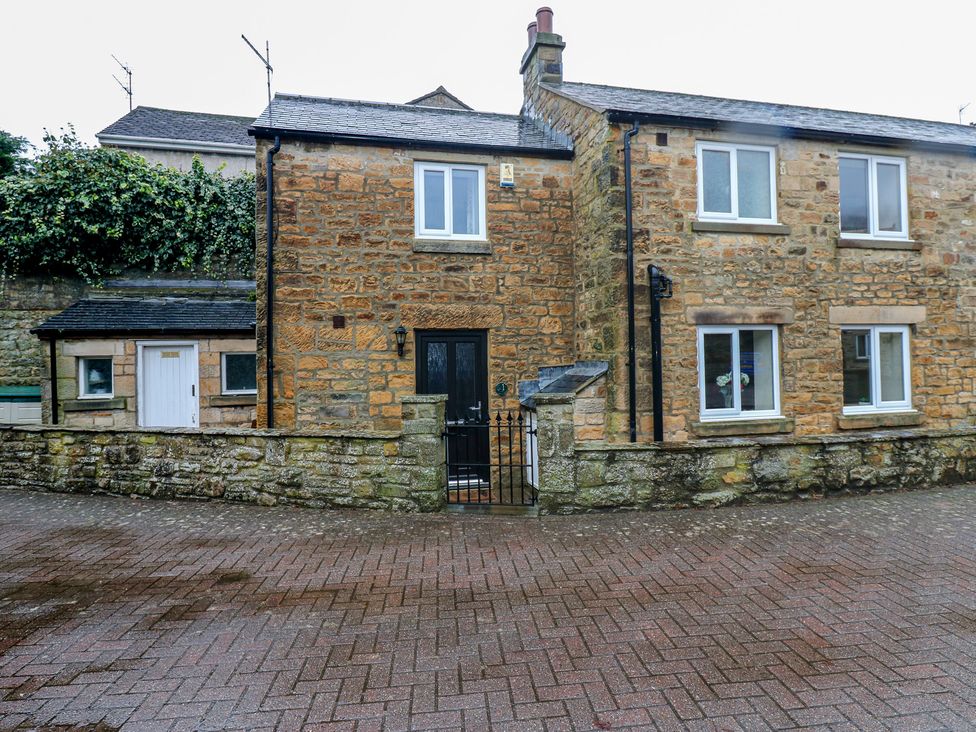 A building with a stone wall and windows at 1 Kyles Yard Barnard Castle