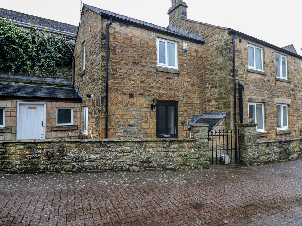 A stone house with a gate and fence at 1 Kyles Yard in Barnard Castle