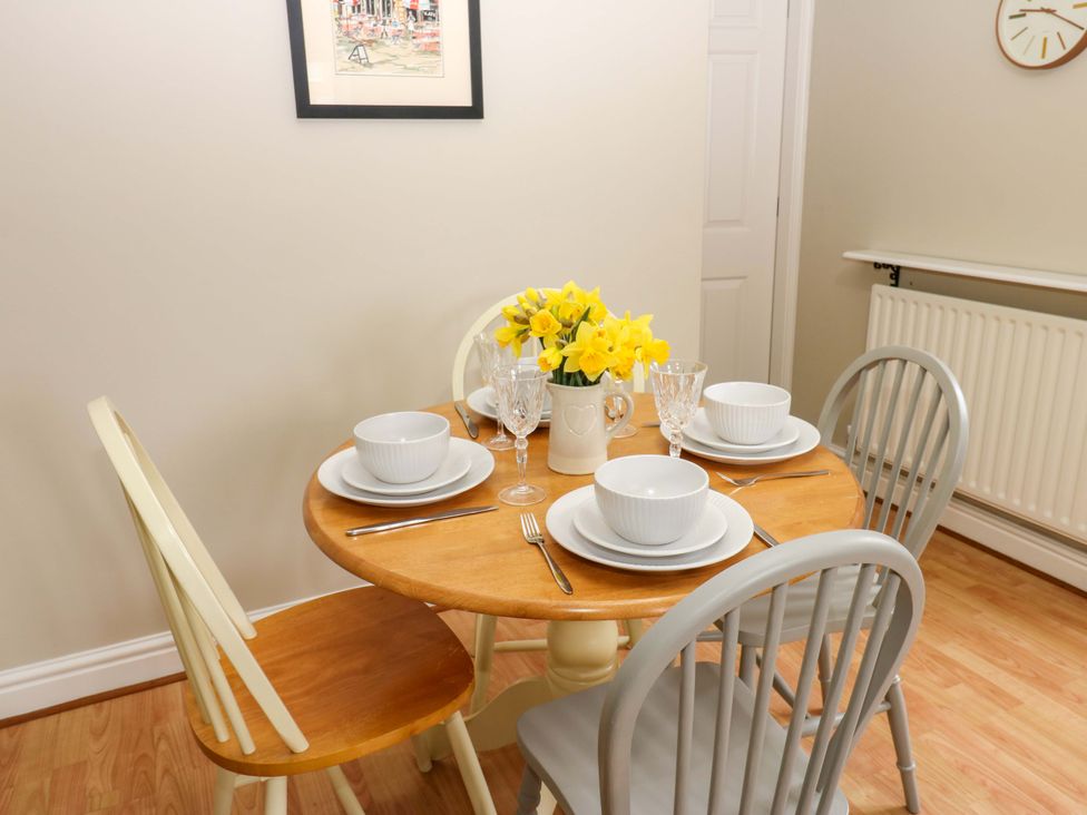 A dining room with a round table set for four at 1 Kyles Yard Barnard Castle