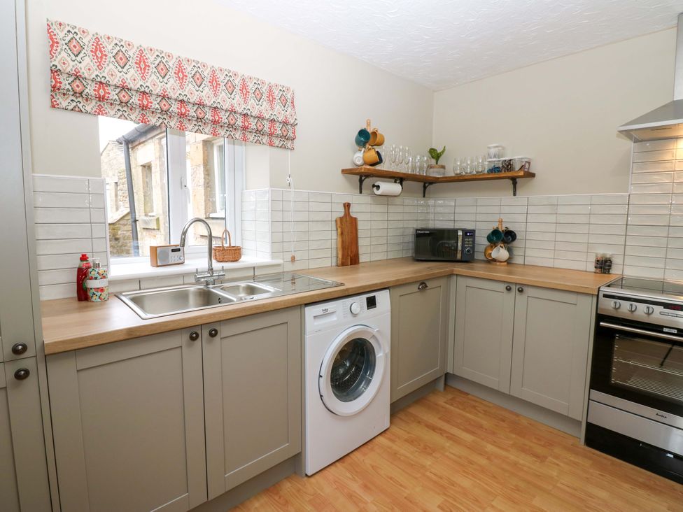 A kitchen with a sink and washing machine at 1 Kyles Yard in Barnard Castle