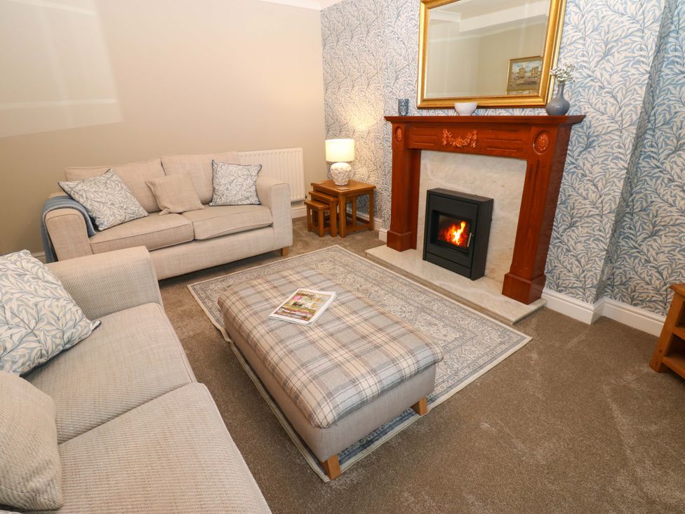 A living room with a fireplace and seating area at 1 Kyles Yard Barnard Castle