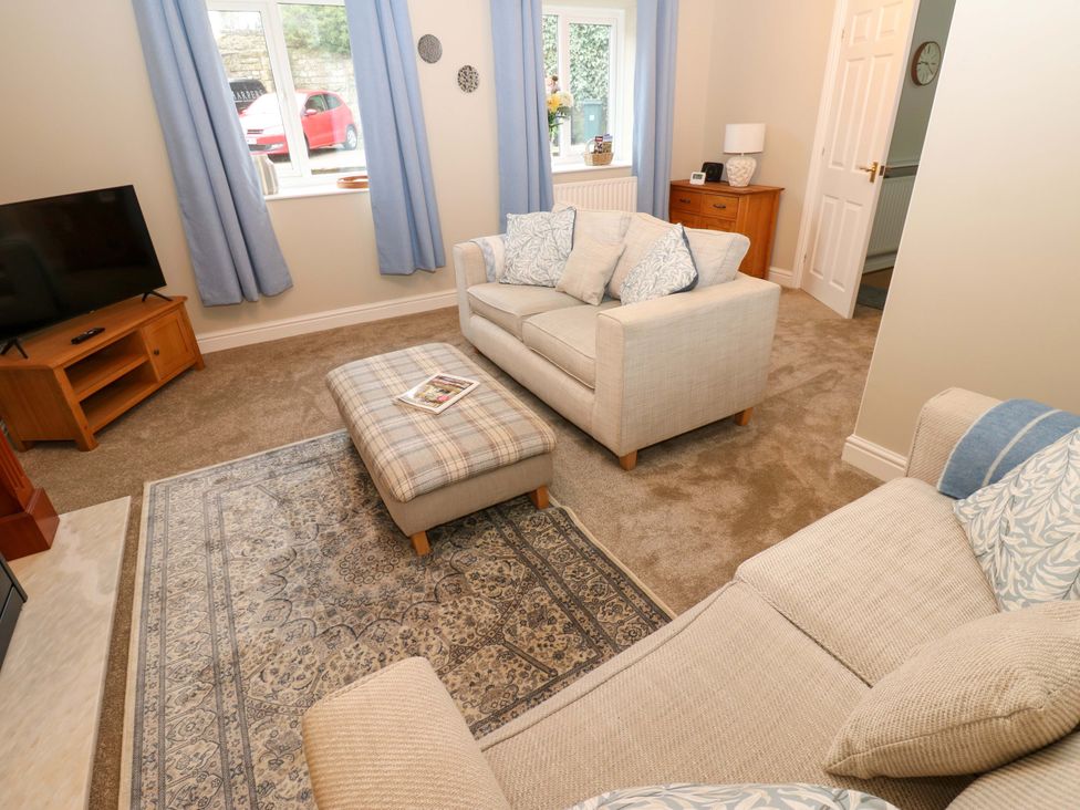 A living room with a sofa and a television at 1 Kyles Yard Barnard Castle