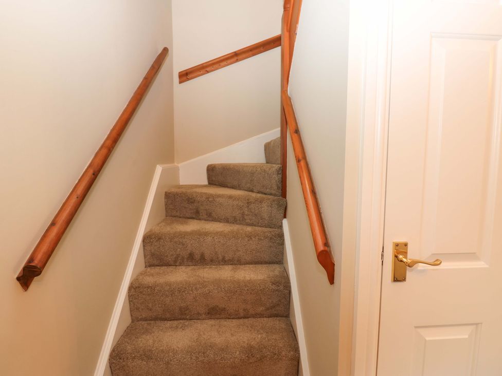 A staircase with carpet steps and a door at 1 Kyles Yard Barnard Castle