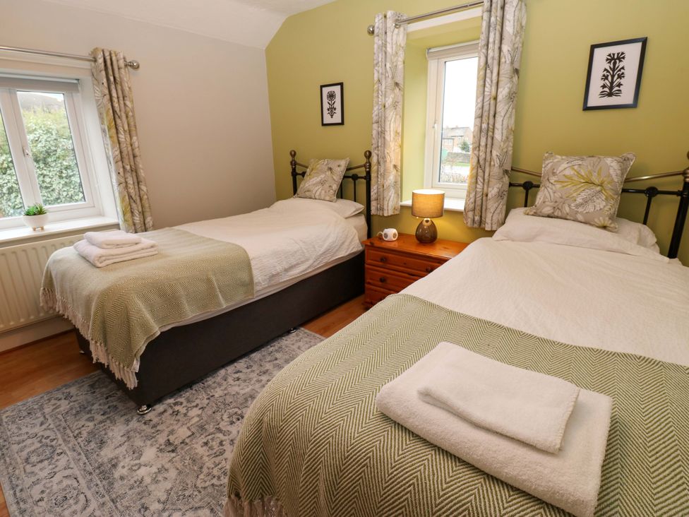 A bedroom with two beds and a nightstand at 1 Kyles Yard Barnard Castle