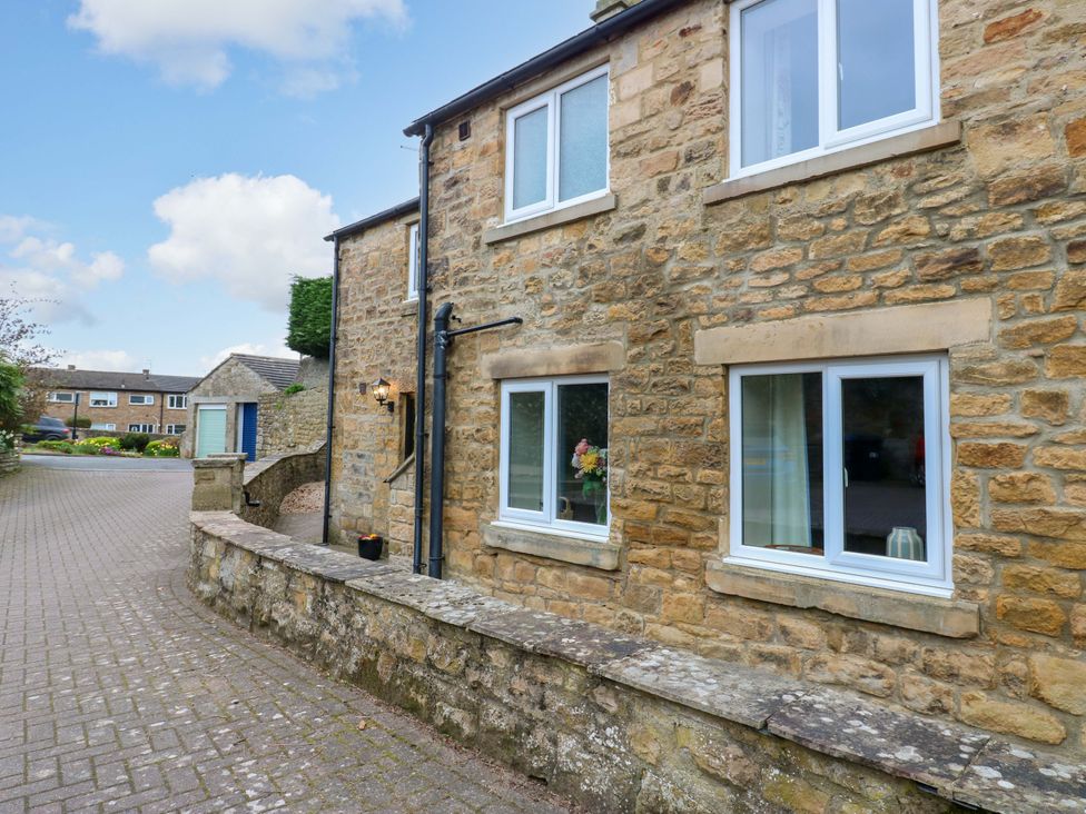 A stone house with windows and a pathway at 1 Kyles Yard Barnard Castle