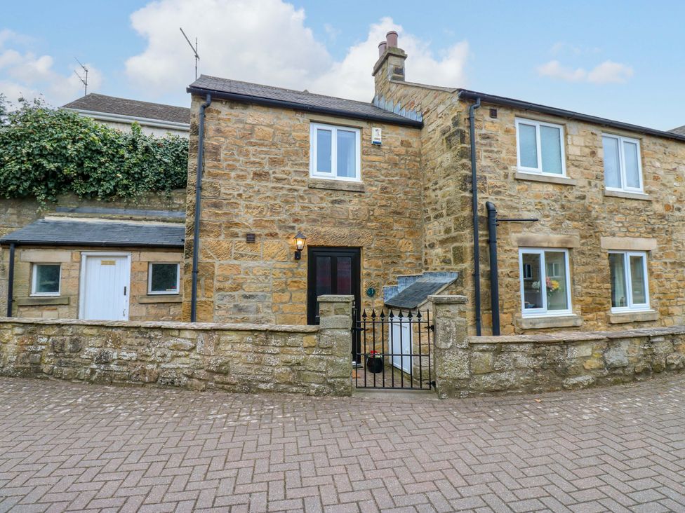 An exterior view of a stone house with a gate at 1 Kyles Yard Barnard Castle