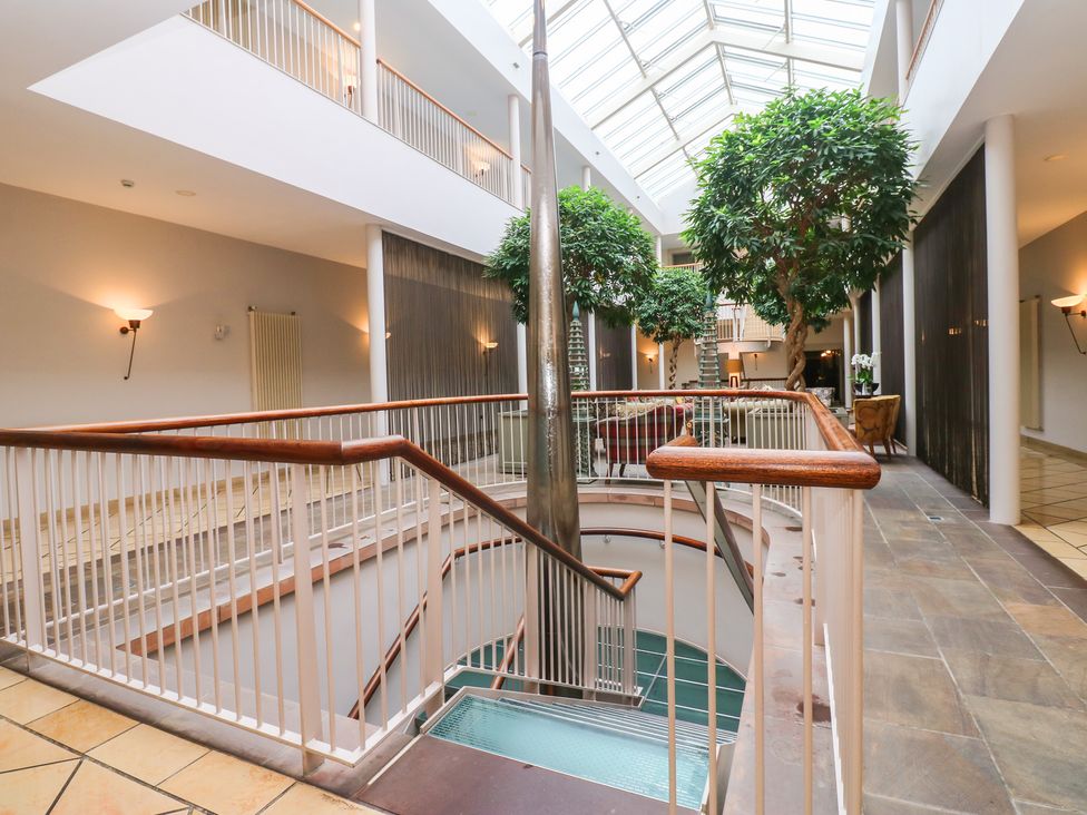 An atrium with a staircase and indoor plants at Costal Lodge at Seaham Hall Seaham