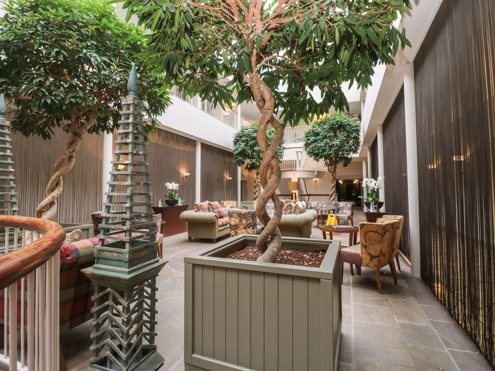 A lobby with seating and indoor trees at Costal Lodge at Seaham Hall in Seaham