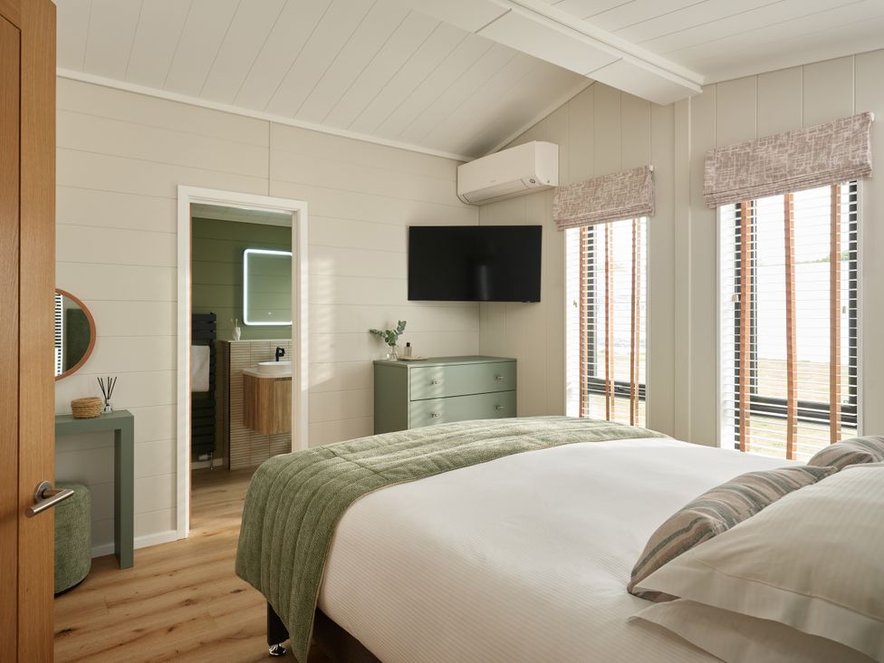 A bedroom with a bed and television at Costal Lodge at Seaham Hall in Seaham