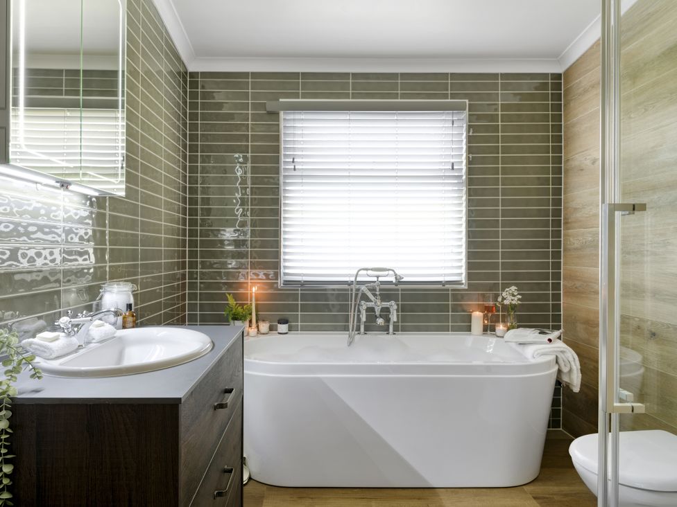 A bathroom with a bath tub, sink, and toilet at Costal Lodge at Seaham Hall in Seaham