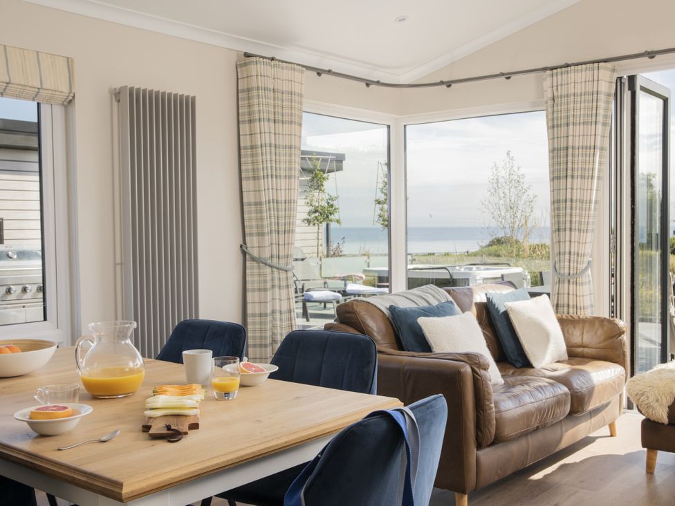 A living room with dining table and couch at Costal Lodge at Seaham Hall in Seaham
