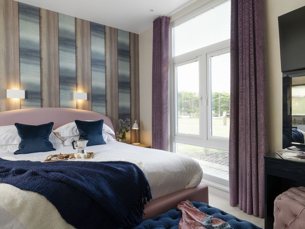 A bedroom with a bed and bedside table at Coastal Lodge at Seaham Hall Seaham