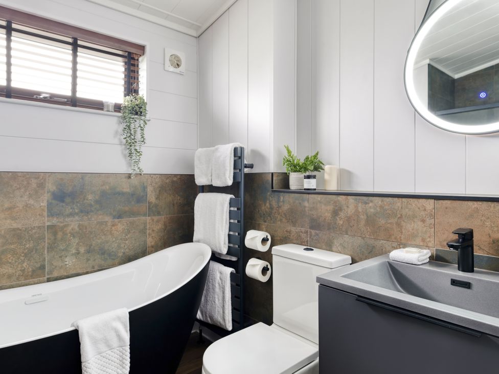A bathroom with a bathtub and sink at Costal Lodge at Seaham Hall in Seaham
