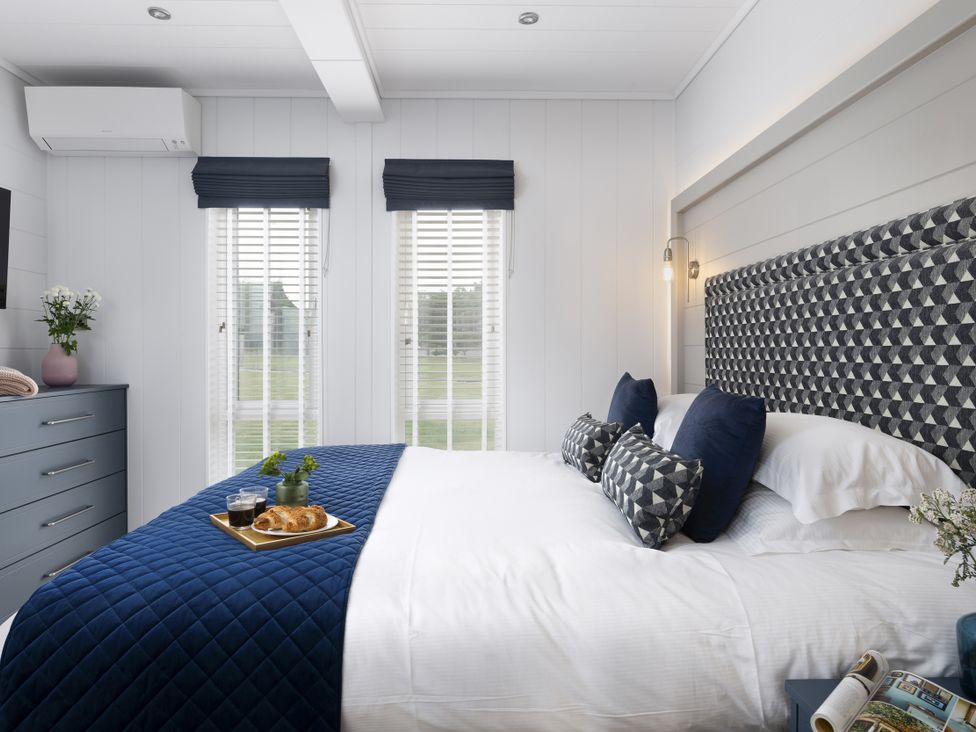 A bedroom with a bed and dresser at Costal Lodge at Seaham Hall, Seaham