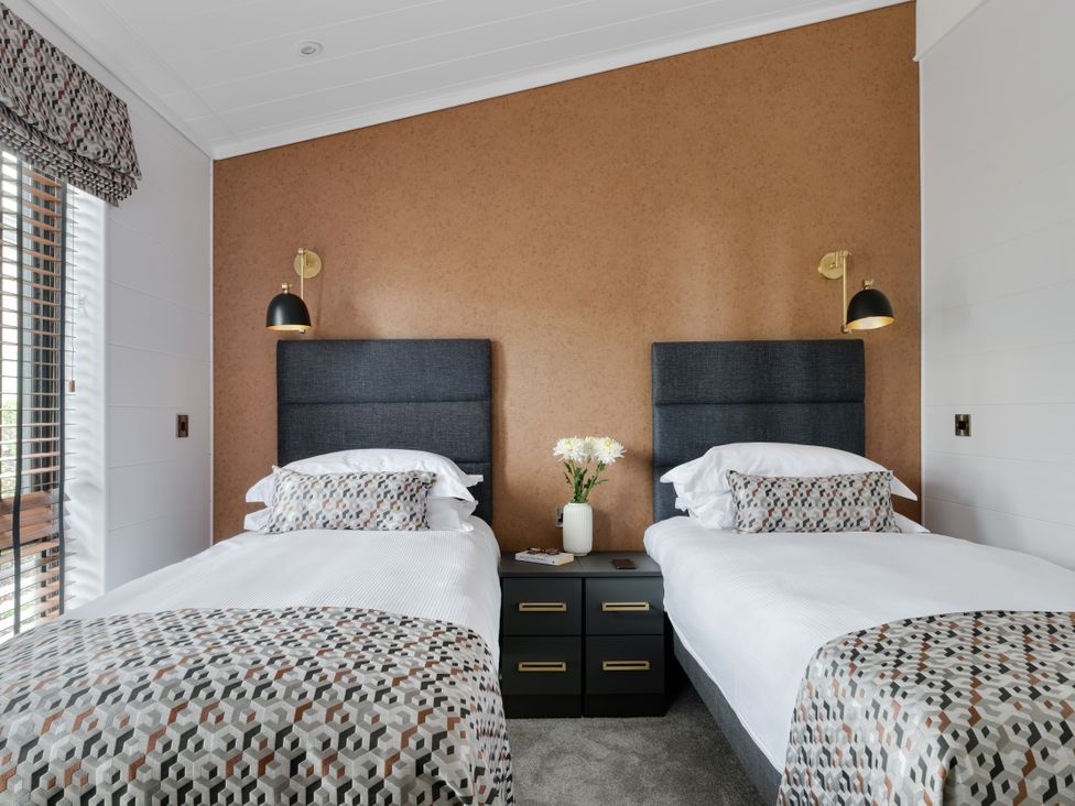 A bedroom with two beds and a bedside table at Costal Lodge at Seaham Hall, Seaham