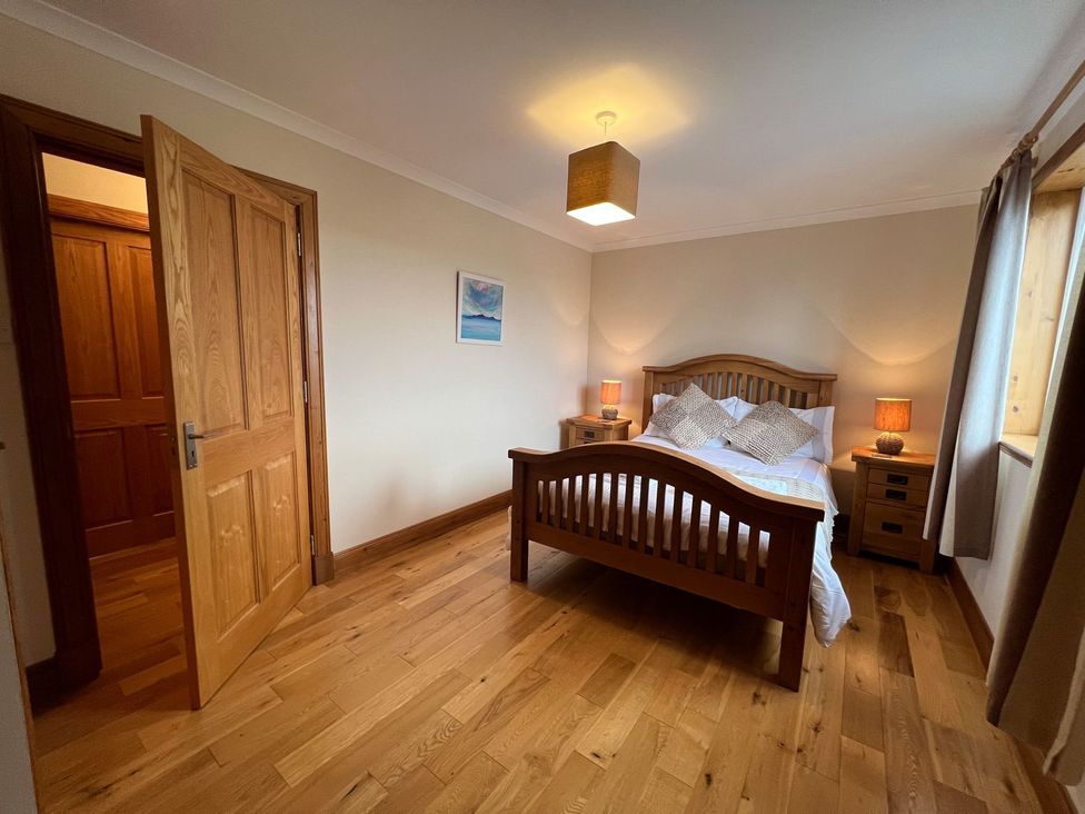 A bedroom with a bed and nightstands at Airigh nam Fiadh in Creagorry